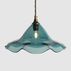 Teal pendant light with wavy glass shade on a white background