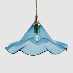 Blue glass pendant light with a gold fixture on a white background
