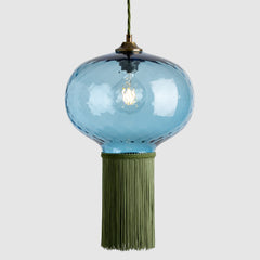Blue glass pendant light with green fabric fringe on a white background