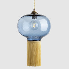 Decorative pendant light with a glass shade and fringe on a white background