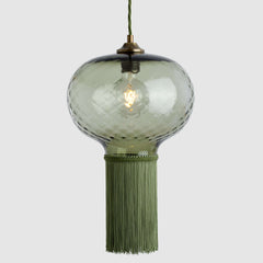 Decorative pendant light with glass shade and tassel on a white background