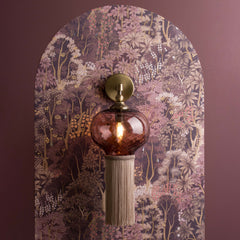 Glass and metal wall sconce hanging on wall with burgundy paint and floral wallpaper