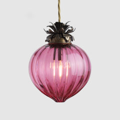 Pink glass pendant light with decorative metal fixture on a white background