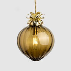 A sargasso green ribbed pendant light with a decorative pressed metal floral holder and a gold-coloured top.