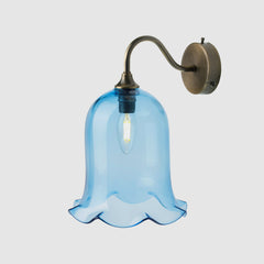 Wall-mounted light fixture with a blue glass shade on a white background