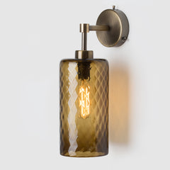 Wall-mounted lamp with smoke sargasso glass shade and brass fixture on a white background