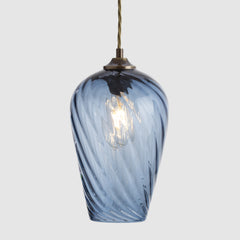 Twisted optic blue glass pendant light with a white background
