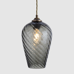 Smoky glass pendant light with a visible bulb on a gray background