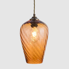 Peach hand blown glass pendant light on a white background