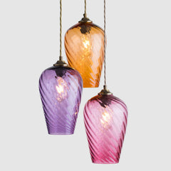 Three colorful glass pendant lights on a white background