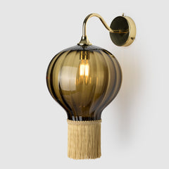 Coloured blown glass ball  light shade with fabric fringing  on a polished brass wall arm