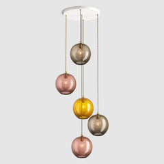 Group of warm amber and brown diamond sphere glass pendant lights on ceiling plate with brass fittings and fabric covered flex