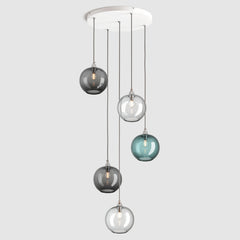 Group of blue, clear and grey plain sphere glass pendant lights on ceiling plate with silver fittings and fabric covered flex