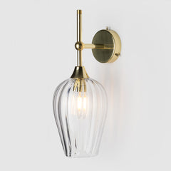 Coloured optic pattern blown glass ball light shade on a polished brass wall arm