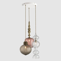 Mix of decorative coloured glass pendant lights with metal detail and fabric covered flex hanging on a ceiling plate