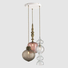Mix of decorative coloured glass pendant lights with metal detail and fabric covered flex hanging on a ceiling plate