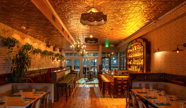 Pendants by Rothschild & Bickers hanging over a bar designed by Assembly Design Studio