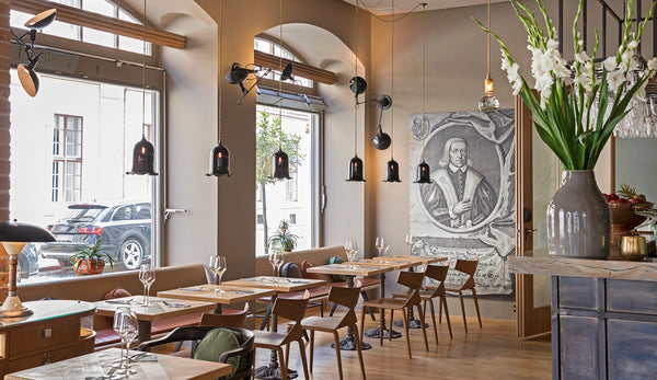 Nouveau bell pendants by Rothschild & Bickers hanging over tables at Restaurant Horschel