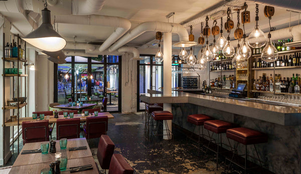 Bespoke glass pendants by Rothschild & Bickers hanging over bar at Whyte & Brown London