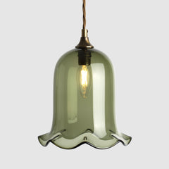 Bell shaped coloured glass light shade with frilled bottom on twisted fabric covered flex