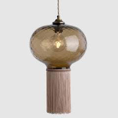 Decorative pendant light with a glass shade and tassel on a white background