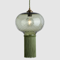 Decorative pendant light with glass shade and tassel on a white background