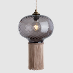 Smoky glass pendant light with tassel on a white background