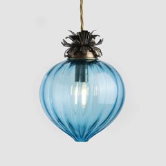 Blue glass pendant light with brass fixture on a white background