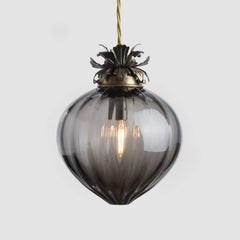 Smoked glass pendant light with brass fixture on a white background