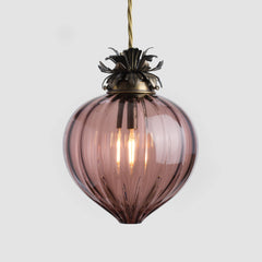 Tea/soft pink glass pendant light with brass fixture on a white background