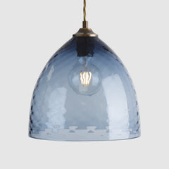Textured blue glass pendant light in bowl shape with a white background