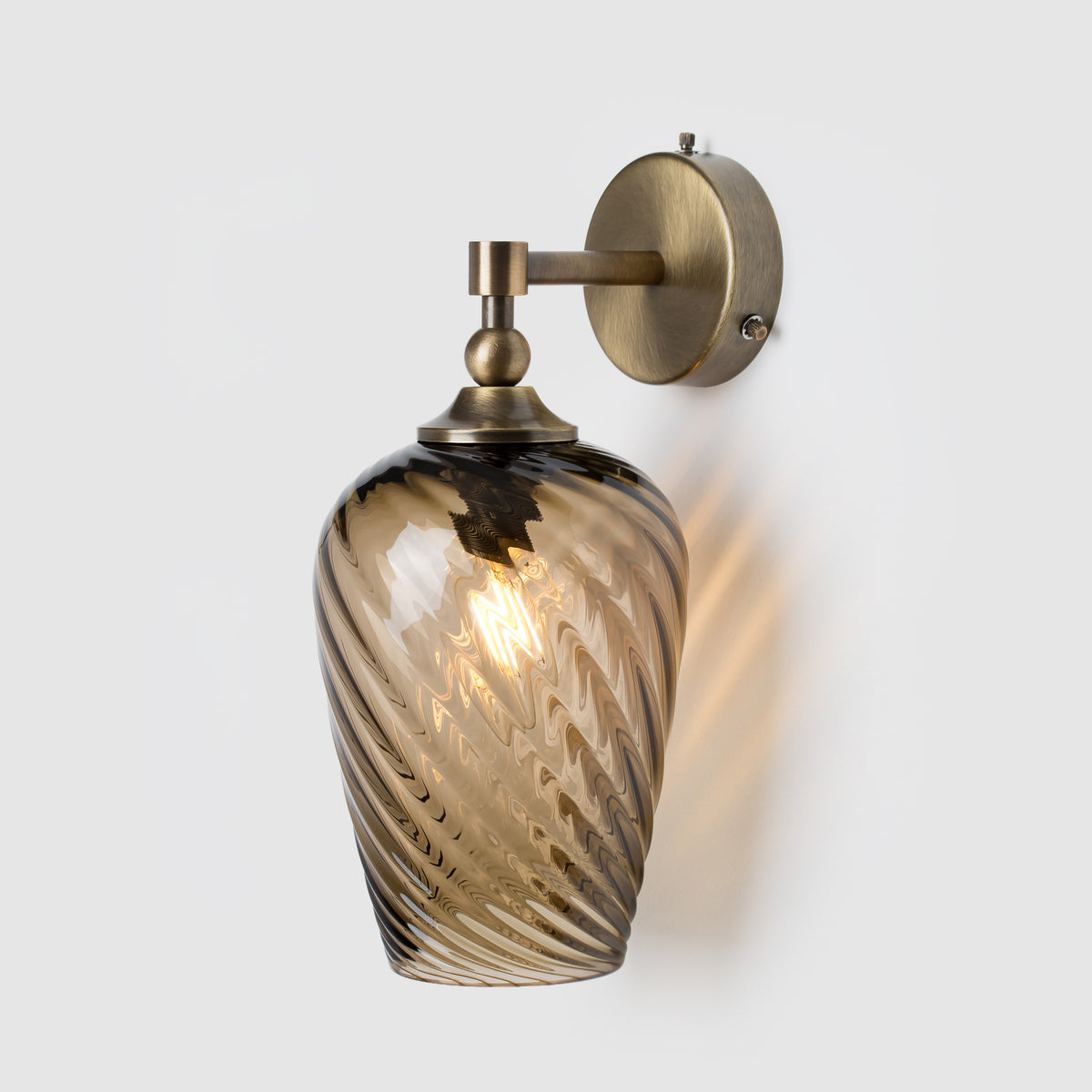 Wall-mounted light fixture with bronze colour and smoked glass shade