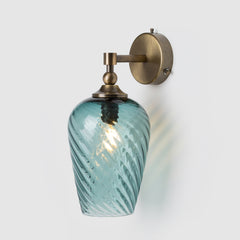 Wall-mounted light fixture with a teal glass shade