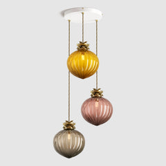 Group of amber, tea and bronze coloured pendant lights in ribbed glass and decorative floral metalwork hanging on a ceiling plate