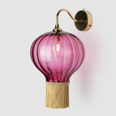 Coloured blown glass ball  light shade with fabric fringing  on a polished brass wall arm