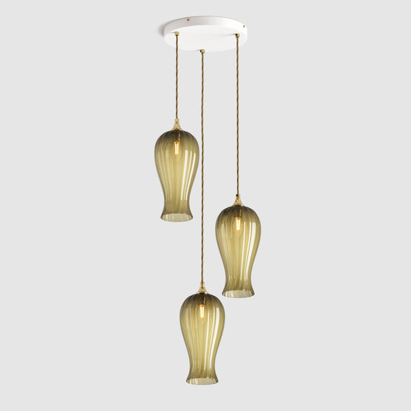 Group of Long ribbed sargasso olive green coloured glass decorative pendant lights with brass fitting and fabric covered flex, hanging on a ceiling plate