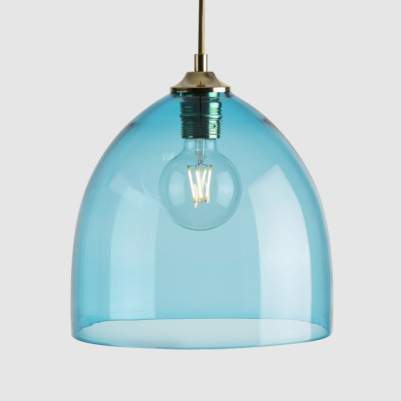 Blue cloche shaped glass pendant light with brass fittings and fabric covered flex