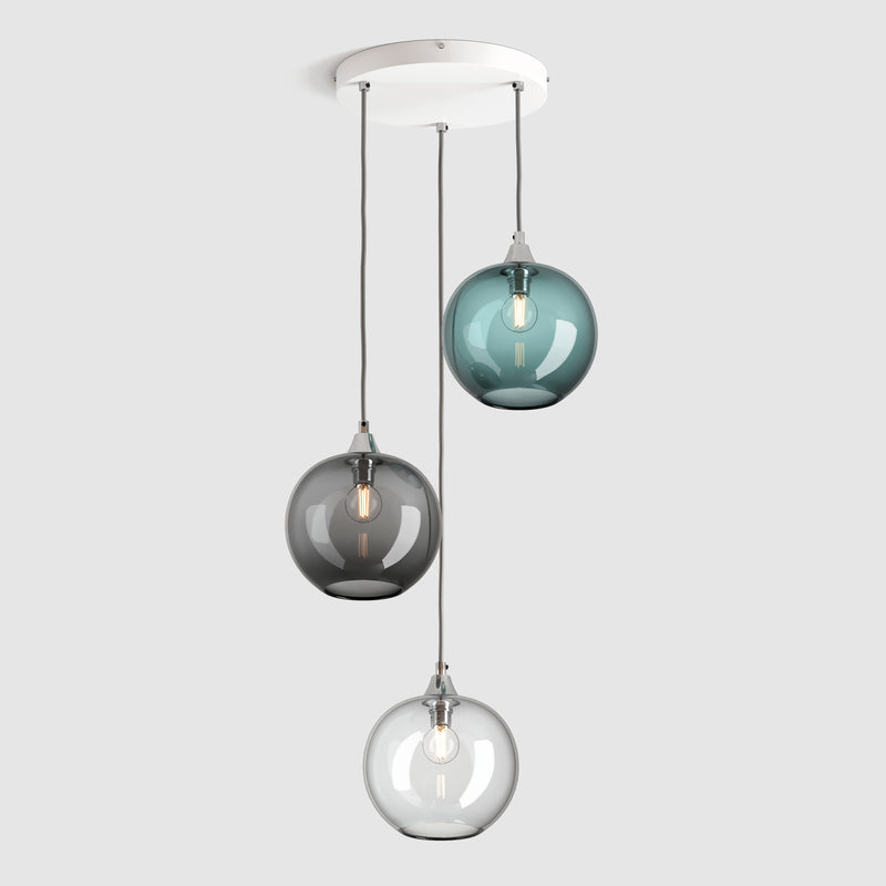 Group of blue, clear and grey plain sphere glass pendant lights on ceiling plate with silver fittings and fabric covered flex