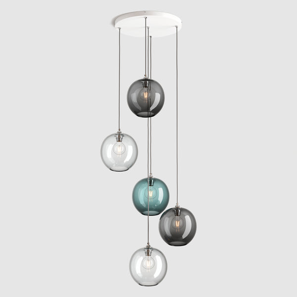Group of warm blue, clear and grey sphere glass pendant lights on ceiling plate with silver fittings and fabric covered flex