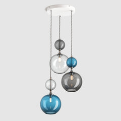 Group of round blue glass pendant lights with decorative metal and fabric covered flex on a ceiling plate