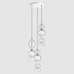 Spindle shaped clear ribbed glass pendant lights hanging on ceiling plate with fabric covered twisted flex