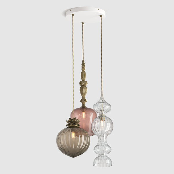 Mix of decorative coloured glass pendant lights with metal detail and fabric covered flex hanging on a ceiling plate